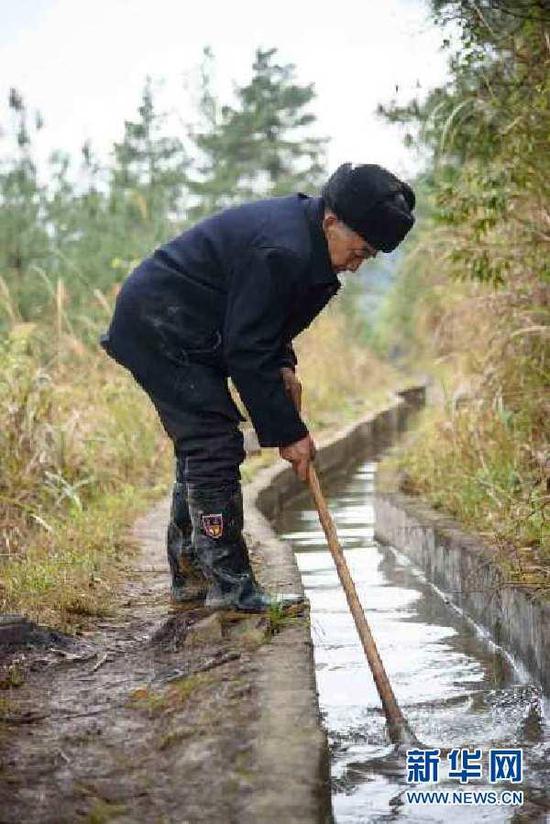 黄大发在清理水渠(3月24日摄)。新华社记者 刘续摄 