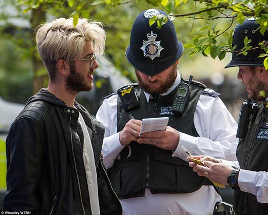 下面张照片中，警察和警犬守在一块警示牌旁。讽刺的是，牌上写着：吸食大麻系违法行为。