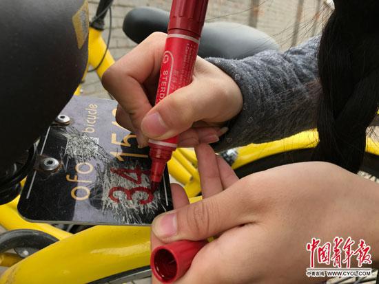  李冬雨正在为共享单车补车牌。中国青年报·中青在线记者 李想/摄
