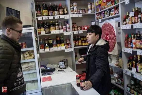 一位白俄罗斯顾客向刘贵宾咨询“老干妈”的吃法（4月15日摄）。