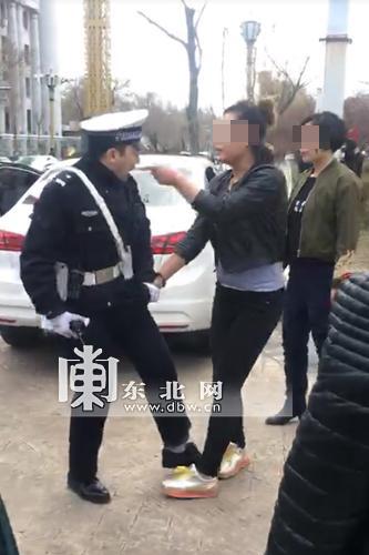 女子当街撕扯并殴打执勤交警的视频截图。