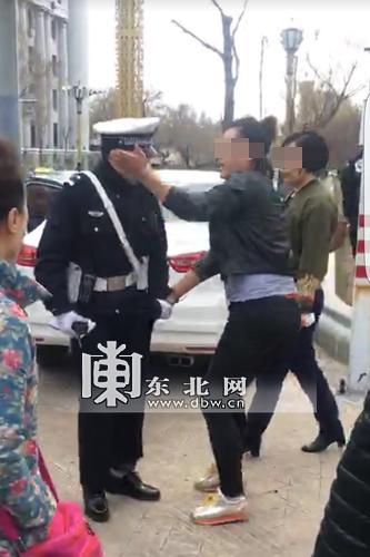 女子当街撕扯并殴打执勤交警的视频截图。