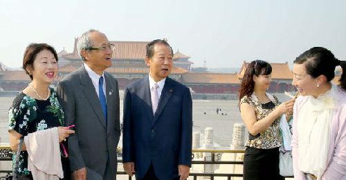 　2015年5月23日，率领3000人访华的二阶俊博（左三）在北京故宫与日本游客交谈。（新华社发）