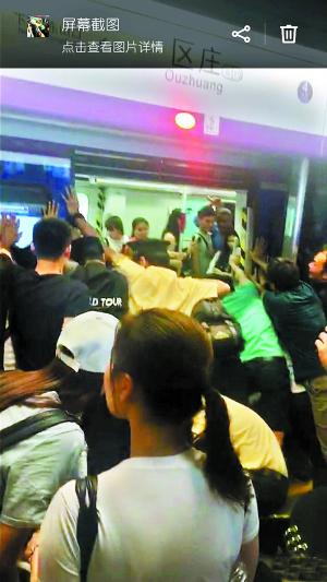 地铁工作人员和众多男乘客合力推地铁车厢。 (图片来自网友朋友圈截图,请作者与本报联系。)