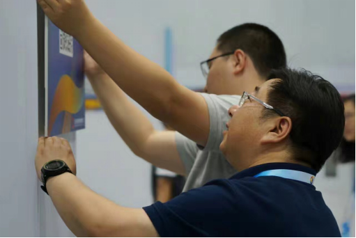 工作人员正在会场张贴“掌上新闻中心”的二维码