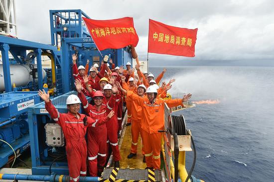 在“蓝鲸一号”钻探平台上，工作人员庆祝天然气水合物试采稳定产气（5月16日摄）。新华社记者 梁旭 摄
