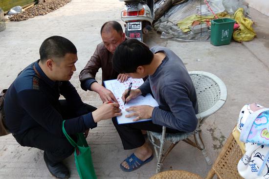 2016年3月,邹士荣(左)和李森源(中)在动员村民加入合作社。