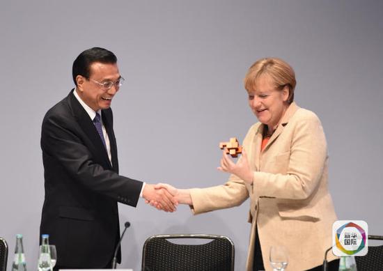 　2014年10月10日，国务院总理李克强在柏林与德国总理默克尔共同出席第七届中德经济技术合作论坛。在论坛上，李克强总理将一个精巧的鲁班锁送给默克尔。新华社记者 李学仁摄 