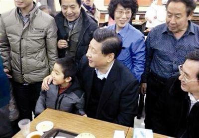 2013年12月28日,习近平在北京市月坛北路庆丰包子铺吃午餐,期间与袁宝小朋友合影。