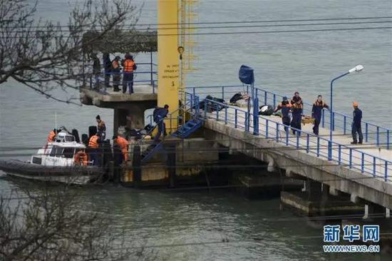 当地时间2016年12月25日，在俄罗斯索契坠机地点附近，搜救人员搬运打捞上来的遇难者遗体。 图/新华社