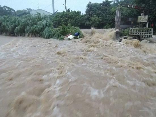 新北淡金公路老梅路段大量雨水冲刷而下，马路变成滚滚黄河。