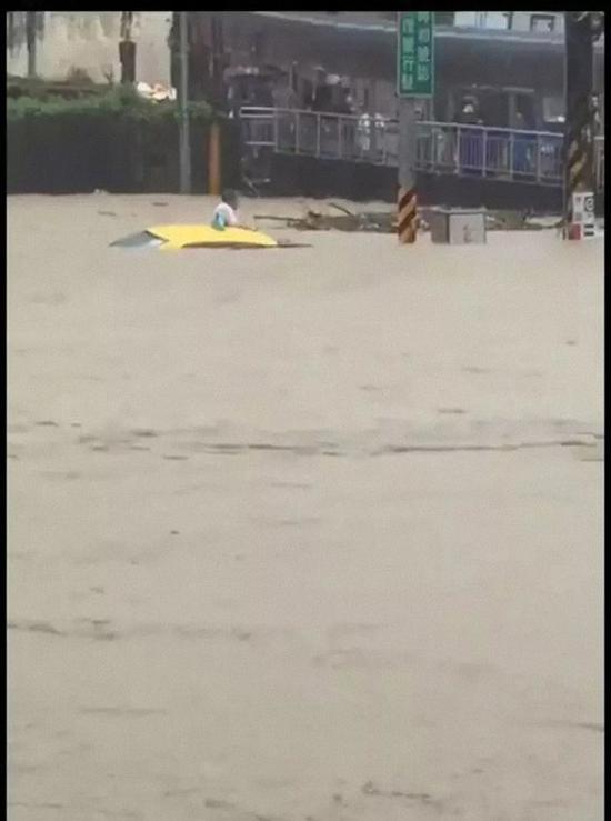 基隆大武仑情人湖路口有出租车被瞬间涌入的雨水淹没，惨遭灭顶，司机惊险逃离。