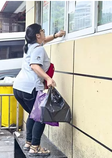 一位女乘客正踩在长凳上准备扒开窗口问询。