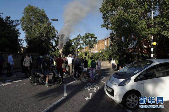 6月14日，在英国伦敦，人们聚集在发生火灾的大楼附近。 