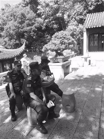 景区保安拿着喇叭对着“合唱团”播放“文明公约”。