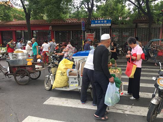 清晨6点王城公园门口,买菜的多是大爷大妈,8点钟摊铺全部收摊。