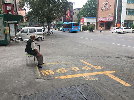 清晨6点洛阳街头,一位大爷坐在街边听收音机。