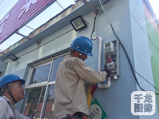 　两周前，北京市朝阳区王四营乡孛罗营村开始了"煤改电"工程。图为施工人员在改造电表。千龙网记者 薄晨棣摄 