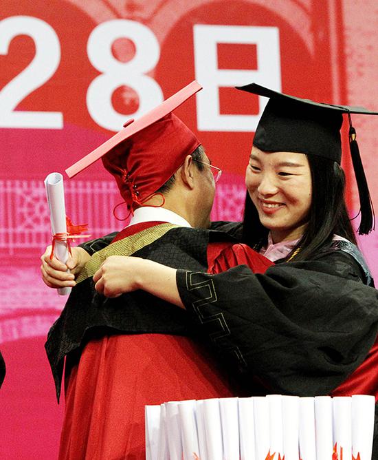 6月28日，苏州大学毕业典礼，一名获得毕业学位的女生与校长熊思东热烈拥抱。