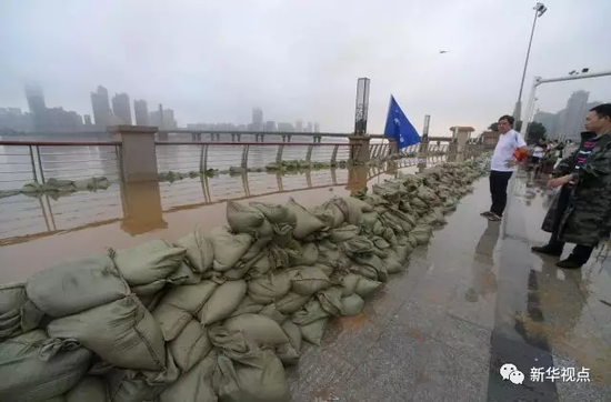 图为7月2日，工作人员在长沙银盆岭大桥附近湘江沿岸堆积沙袋阻挡洪水。新华社记者 范军威 摄