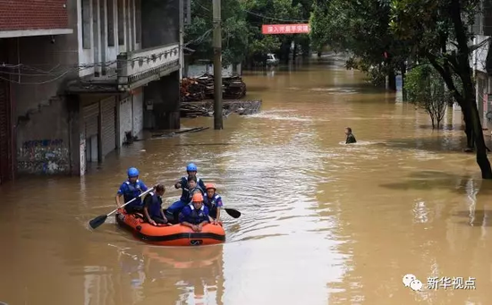 图为7月1日，处于资江流域的湖南益阳市谢林港镇，蓝天救援队队员在被洪水淹没的街道转移群众。新华社记者 李尕 摄