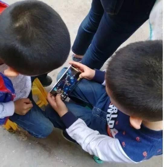 ▲小学生聚在一起玩手机游戏。 图片来自网络