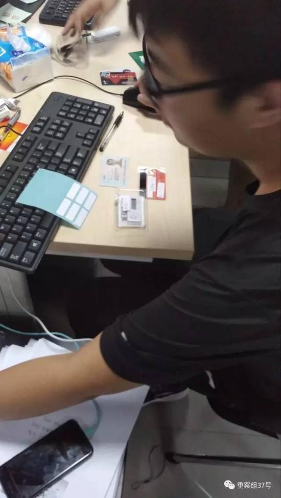 ▲一名事情职员正在磨练“兼职职员”的身份证、银行卡、U盾。视频截图