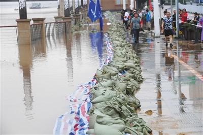 2日，工作人员在长沙城区湘江沿岸搬运沙袋加固子堤。 新华社记者 龙弘涛摄