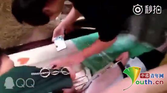 至少三名学生持手机凑近被打女生脸部举行拍摄。网络视频截图。