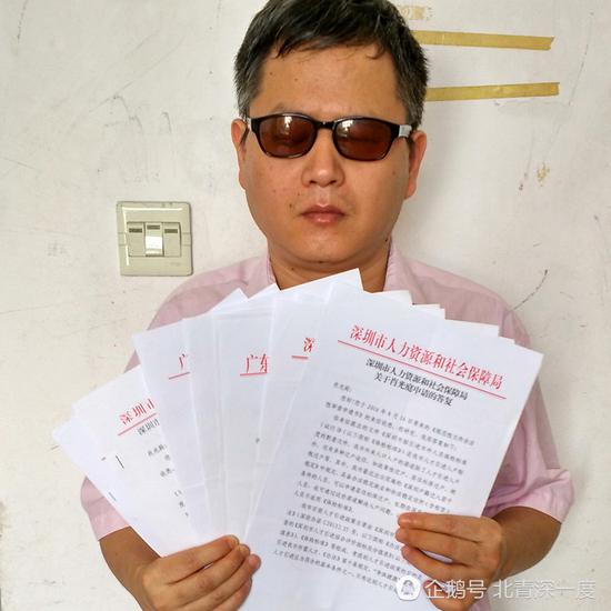 盲人肖光庭拿着各部门关于“积分入户”政策的回复