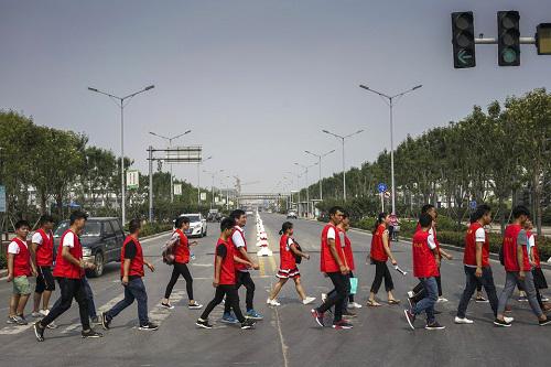 iPhone组装厂的富士康工人在郑州工厂间穿行。（美国《华尔街日报》）