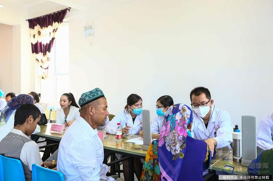 7月10日，来自北京市18位医务工作者到新疆和田洛浦县恰尔巴格村，为这里的村民展开爱心义诊活动。图为爱心义诊现场。记者 许珠珠摄