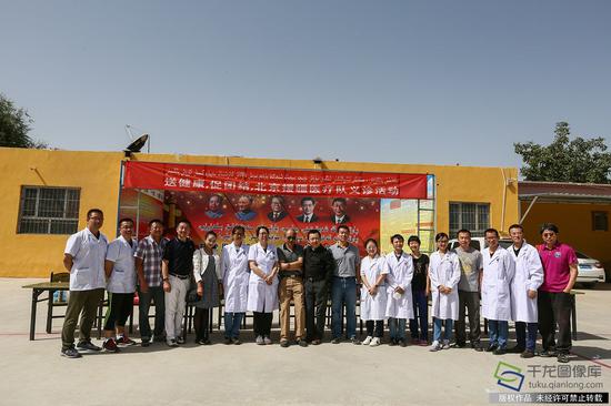 7月10日，来自北京市18位医务工作者到新疆和田洛浦县恰尔巴格村，为这里的村民展开爱心义诊活动。图为北京市援疆医生集体合影留念。记者 许珠珠摄