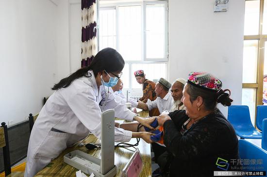 7月10日，来自北京市18位医务工作者到新疆和田洛浦县恰尔巴格村，为这里的村民展开爱心义诊活动。图为北京市援疆医生给患者做身体检查。记者 许珠珠摄