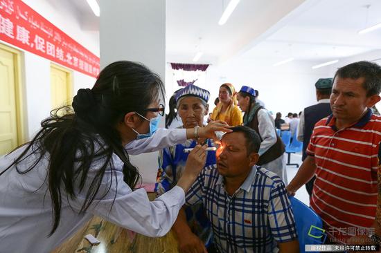 7月10日，来自北京市18位医务工作者到新疆和田洛浦县恰尔巴格村，为这里的村民展开爱心义诊活动。图为北京市援疆医生在给患者做眼部检查。记者 许珠珠摄