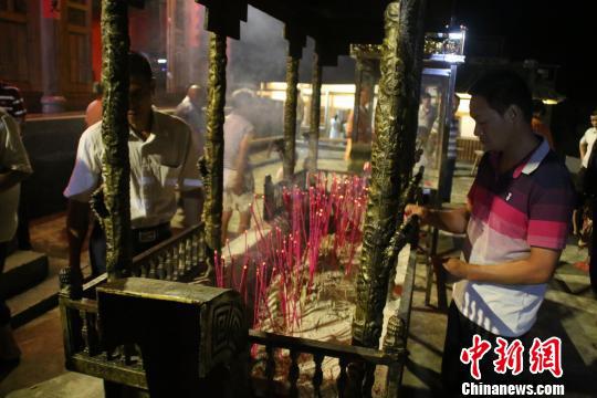  村民在普照堂上香祈祷章公祖师还乡。 林文青摄 