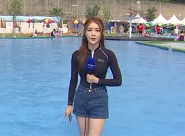 气象女主播权惠仁站在泳池报天气