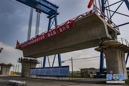7月10日,中铁四局工作人员在湖北省襄阳市襄州区境内的郑万铁路白河特大桥架梁。新华社记者杜华举摄