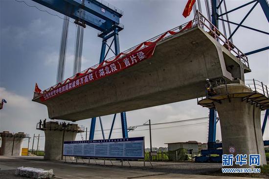 7月10日，中铁四局工作人员在湖北省襄阳市襄州区境内的郑万铁路白河特大桥架梁。新华社记者杜华举摄