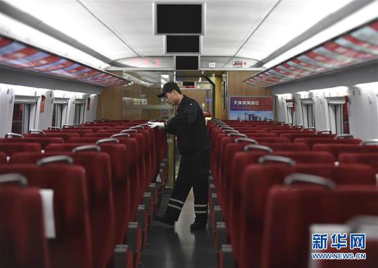 1月25日凌晨，天津动车运用所的工人在车厢内检查座椅。新华社记者 连漪 摄