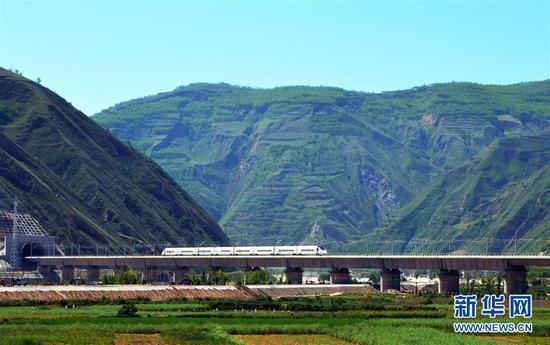 7月9日，一列高铁列车行驶在宝兰高铁甘肃天水段南河川大桥上。近年来，中国高铁继续保持快速发展步伐，“四纵四横”高铁网基本成形，技术成就赢得国际声誉，服务品质不断攀升。中国高铁已经成为一张见证时代发展的名片。新华社发（武龙 摄）