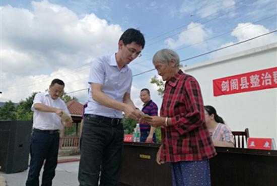 村民从剑阁县纪委书记母雪龙手中领到退返的2600余元违纪款项。成都商报图