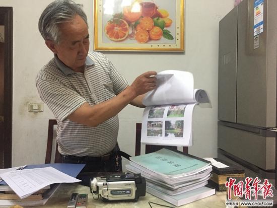 骆礼全展示他20年的环保维权资料。中国青年报<span class=