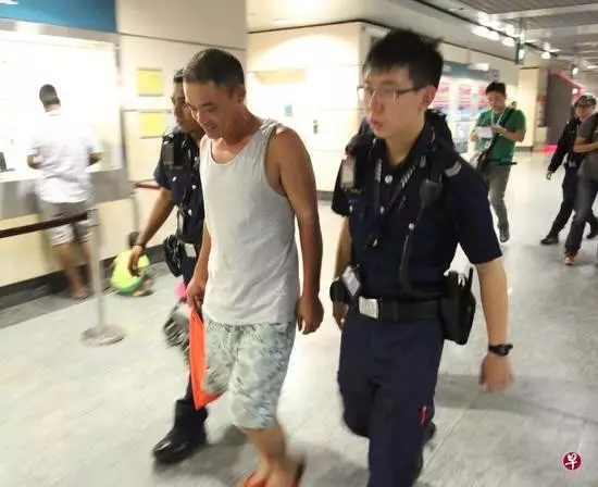▲因行李箱遗留新加坡地铁引发恐慌,王建坡(穿背心者)被控公共滋扰罪 图据联合早报网