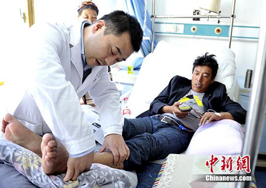 资料图：北京天坛医院的外科专家为脚部跟骨粉碎性<a href='http://health.sina.com.cn/disease/ku/00158/' target='_blank'>骨折</a>的患者检查。 中新社发 李林摄