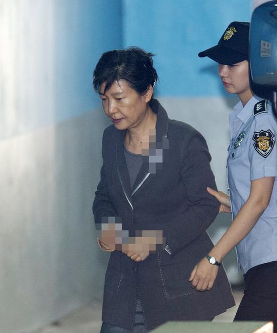 25日，朴槿惠出庭受审，她面无表情、身体蜷缩走向法院