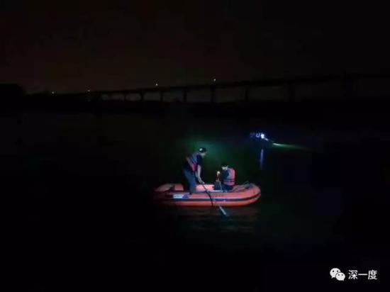  △夜幕下，救援队站在北京的一处水塘内搜寻溺亡者