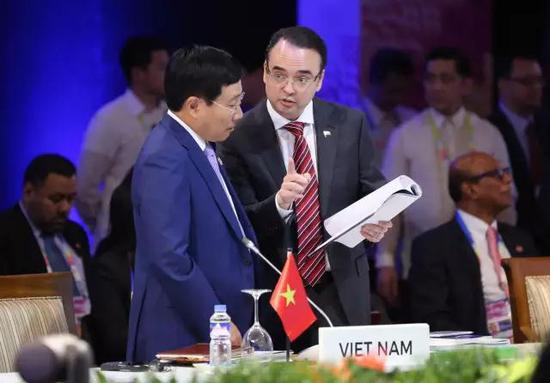 ▲菲律宾外长卡亚塔诺与越南外长范平明在集会现场举行交流。（东盟官网）