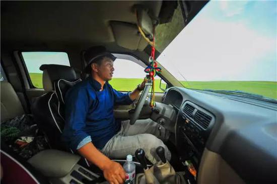 内蒙古自治区新巴尔虎右旗克尔伦苏木芒来嘎查党支部书记米吉格驾车行驶在牧场上（7月17日摄）。新华社记者 连振 摄