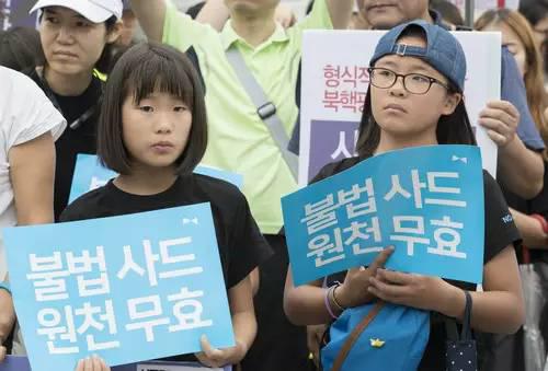 ▲7月31日，在韩国首尔国防部门前，韩国民众高举反对部署“萨德”系统的标语参加抗议集会。
